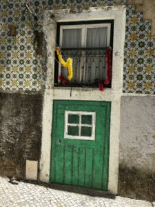 A painting of a green door in Lisbon.