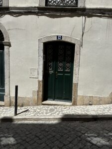 A green door on a street in Lisbon.